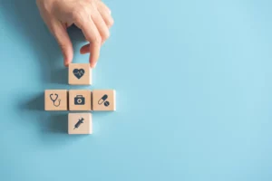 Health Insurance Concept, Hand of woman arranging wood cube stacking with icon healthcare medical on blue background Direct Primary Care's Role